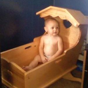 Grandson playing in sissy's cradle