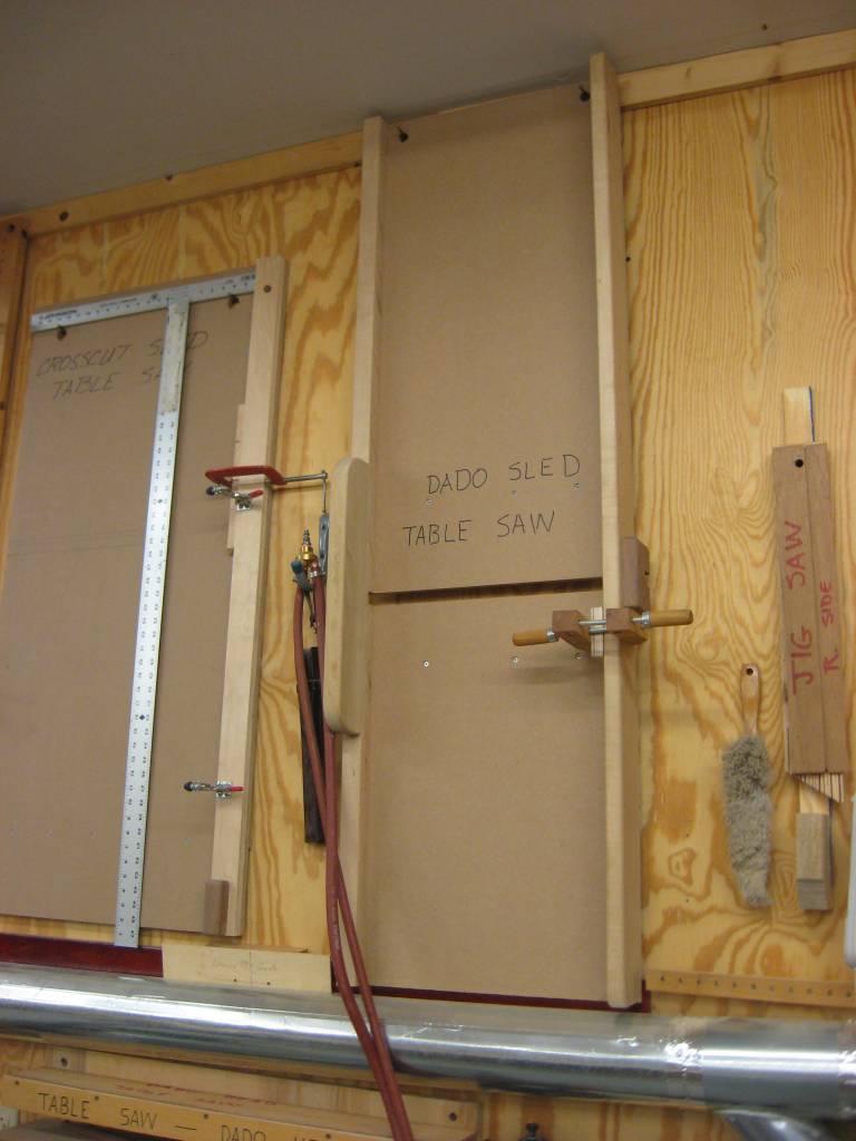 Table saw jigs hanging on wall